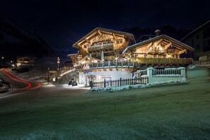 Un edificio de estilo chalet de madera con un restaurante y un bar en la planta baja, rodeado de nieve.