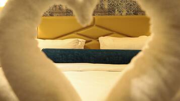 A bed with a geometric headboard, white pillows, and a dark blue accent pillow.