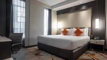 Una camera d'albergo moderna con un letto grande, una scrivania e una sedia.
