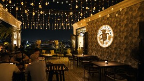 An outdoor dining area with string lights, tables, and chairs.
