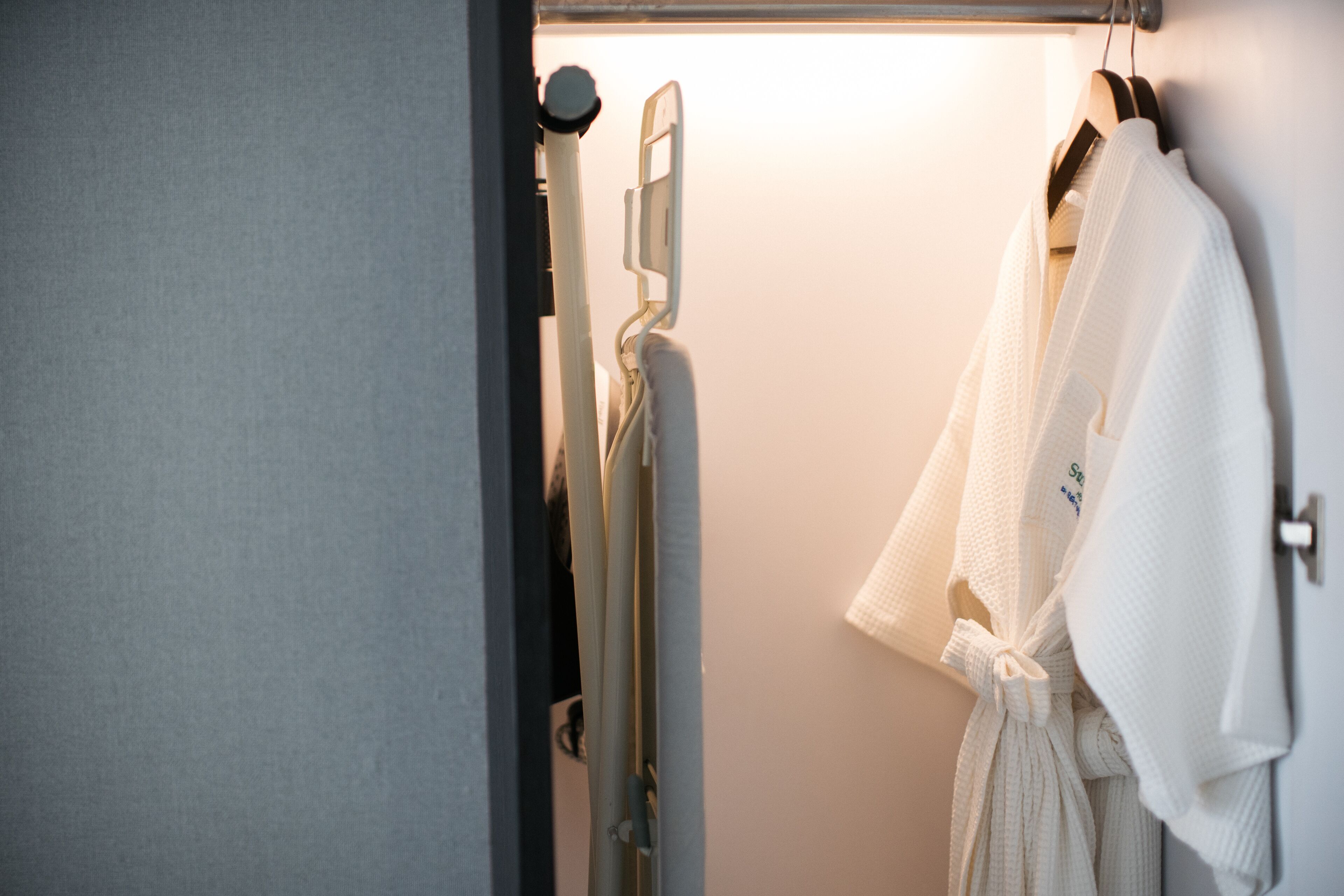 A bathroom with a towel rack holding a white towel and a shower head.