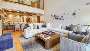 Un salon moderne avec un canapé blanc, une table basse et un coin repas avec des chaises.