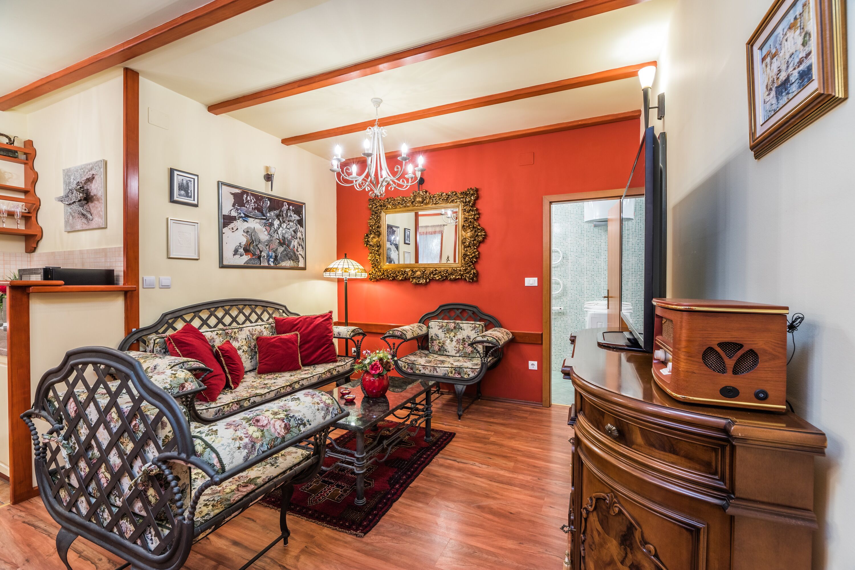 A living room with a sofa set, a wooden cabinet, and a chandelier.