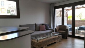 A modern living room with a sofa, armchair, and a glass coffee table. - Realejo Paradise. Penthouse with terrace (Granada)
