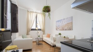 Una sala de estar moderna con un sofá, una mesa de comedor y una zona de cocina.