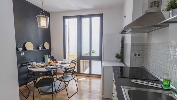 Una cocina compacta con comedor, un ventanal amplio y una estufa moderna.