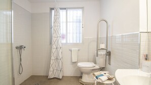 Un baño con ducha, inodoro y lavabo.