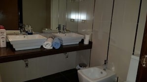 A bathroom with two sinks, a mirror, and a bidet. - Hostal El Pasaje (Puente Genil)
