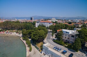 Vista aérea de una ciudad costera con playa, edificios y cielo despejado.