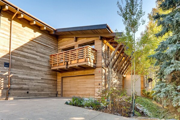 A modern building with a wooden facade, a balcony, and a garage door. - 184 W Meadow Drive, Vail Village Ultra-Luxury Home - Hot Tub, Ski Storage Next to Gondola 1 (Vail)