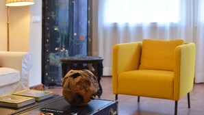 A room with a yellow armchair, a lamp, and a decorative object on a table. - Casa Mozart Hotel Boutique (Las Palmas de Gran Canaria)