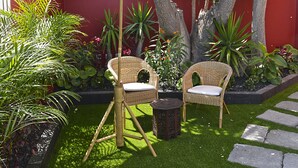 A patio with two wicker chairs, a small table, and an umbrella. - Casa Mozart Hotel Boutique (Las Palmas de Gran Canaria)
