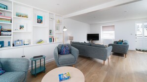 Una sala moderna con un conjunto de sofás, una mesa de centro y una estantería.