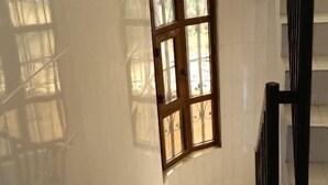 Una escalera con paredes de azulejos blancos y barandilla de madera.