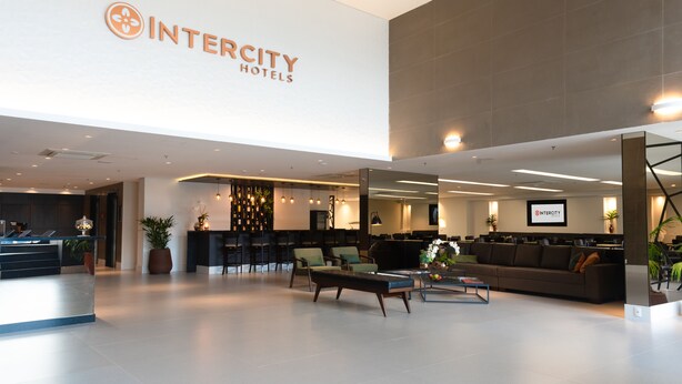 A modern hotel lobby with a reception desk, seating area, and a large Intercity Hotels sign. - Intercity São Paulo Anhembi (São Paulo)