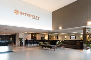 A modern hotel lobby with a reception desk, seating area, and a large Intercity Hotels sign. - Intercity São Paulo Anhembi (São Paulo)