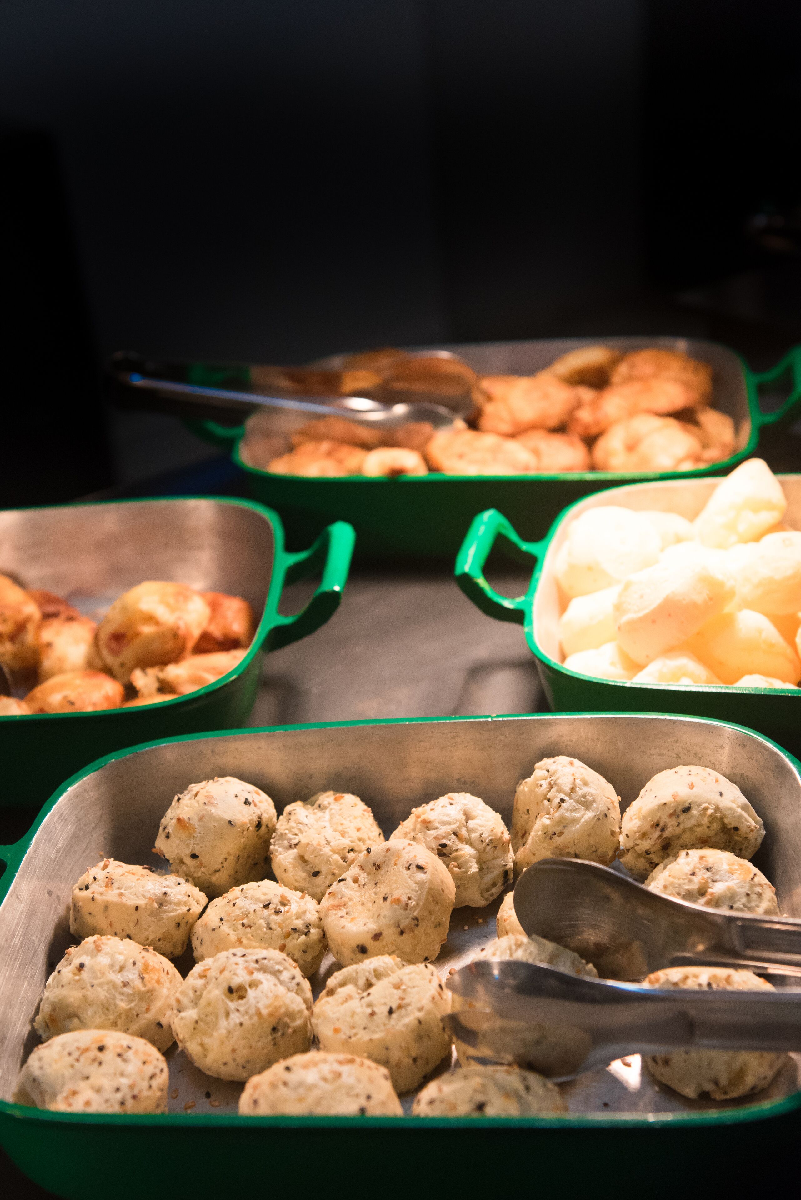 Een buffet met diverse etenswaren in groene serveerschaaltjes.
