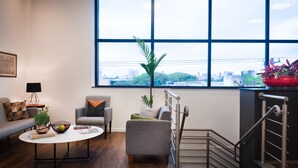 A modern living room with a large window, a sofa, a coffee table, and a staircase. - Intercity São Paulo Anhembi (São Paulo)