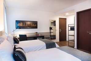 A hotel room with two beds, a desk, a chair, a mirror, and a door. - Intercity São Paulo Anhembi (São Paulo)