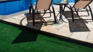 A poolside area with lounge chairs, a small table with a drink, and a view of a cityscape. - Intercity São Paulo Anhembi (São Paulo)