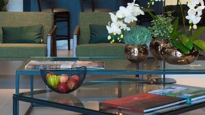 A modern lobby with a glass coffee table, seating area, and a bar with shelves of bottles. - Intercity São Paulo Anhembi (São Paulo)