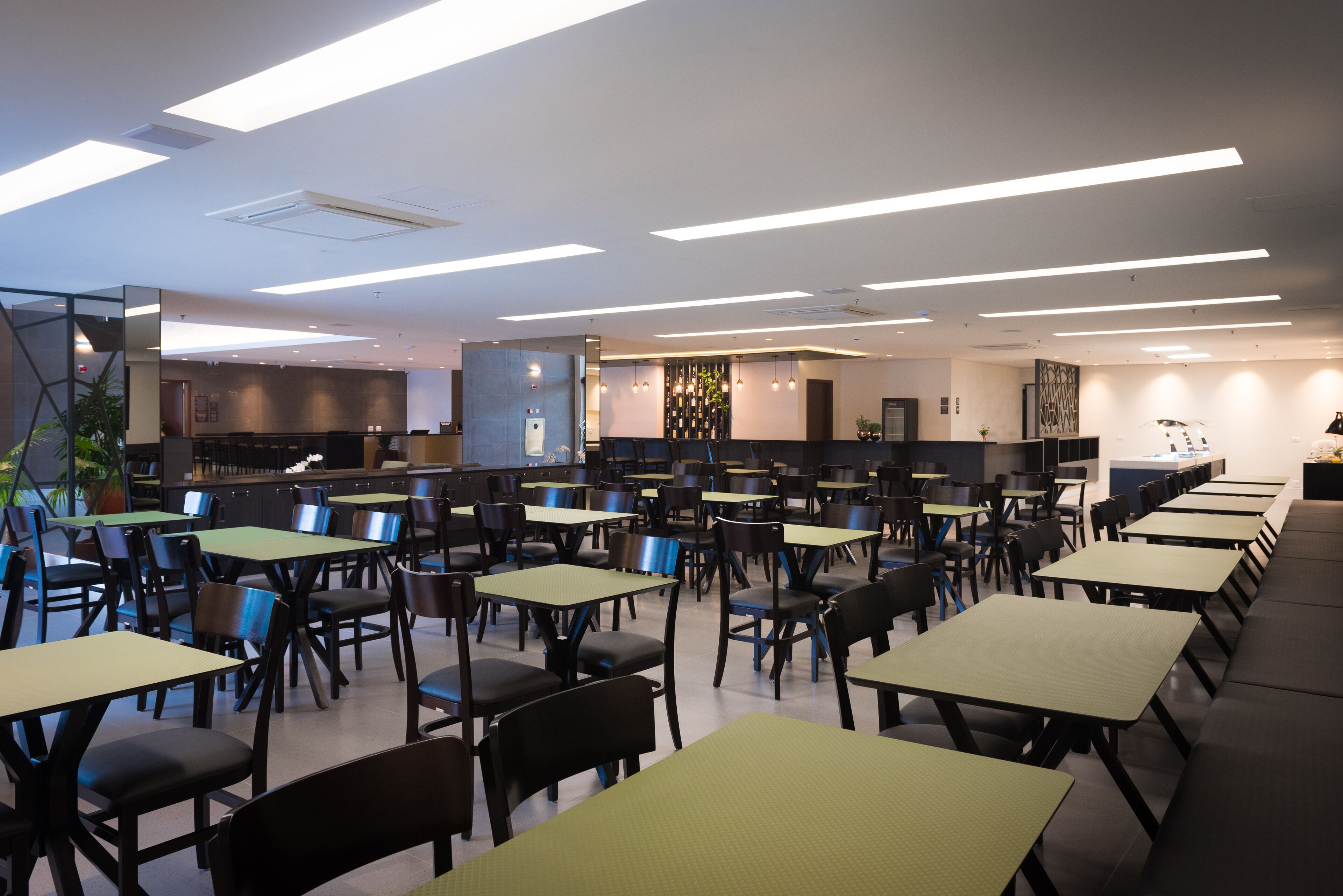 Un restaurant spacieux doté de nombreuses tables et chaises, d’un bar et d’un décor intérieur moderne.