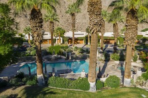 Zona residencial con piscina, palmeras y casas de fachadas blancas.