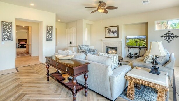 A living room with a sofa, coffee table, fireplace, television, and decorative items. - Duna La Quinta #2 - Fairway Home - Pet Friendly (La Quinta)