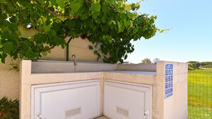 Eine Betonkonstruktion mit Metalldach, zwei weißen Türen und einem Schild, das einen Pool anzeigt.