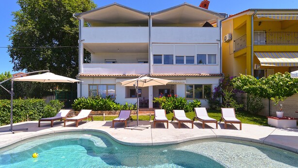 A two-story building with a swimming pool, lounge chairs, and umbrellas. - Apartment 31/41 (Istria - Valbandon), 600m from the beach (Valbandon)