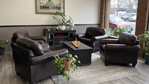 Een moderne woonkamer met leren banken, een salontafel en een boekenplank.