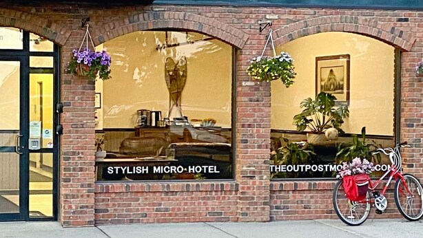 Een gebouw van baksteen met een bord waarop staat '33 West Main' en 'Stijlvol Micro-Hotel'.