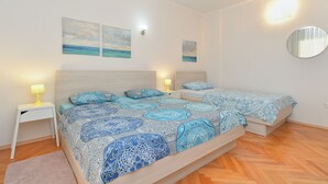 A bedroom with two beds, a nightstand, a bedside lamp, and a mirror. - Apartment 38/49 (Istria - Valbandon), 750m from the beach (Valbandon)