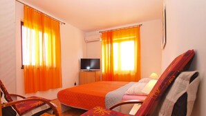 A hotel room with a bed, two chairs, a TV, and curtains. - Apartment 39/52 (Istria - Banjole), 500m from the beach (Banjole)