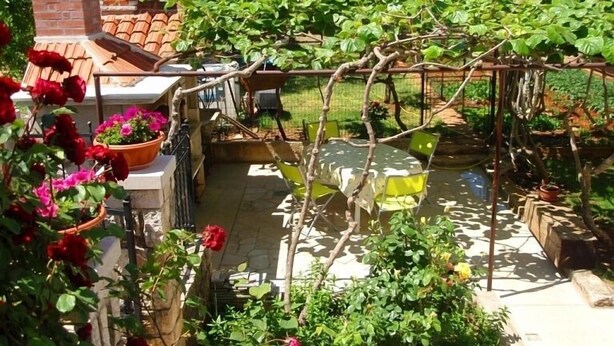 A garden with a pergola, a brick structure, and a tiled patio. - Apartment 41/23324 (Istria - Stinjan), 700m from the beach (Stinjan)