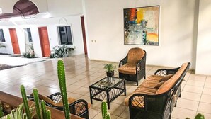 A spacious living area with a sofa set, a coffee table, and a cactus plant.