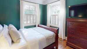 Un dormitorio con cama, cómoda y ventilador de techo.