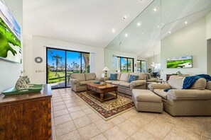 A spacious living room with a large window, a sofa set, a coffee table, and a rug. - PGA West #7 - Fairway 3 bedroom/2 bath, permit 246140 (La Quinta)