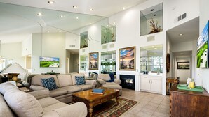 A spacious living room with a sectional sofa, a wooden coffee table, and a fireplace.