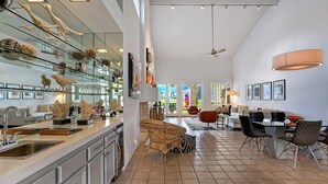 A spacious kitchen with a central island, modern furniture, and a dining area with a view of the outdoors. - Santa Rosa Cove #50, 3 Bedrooms   3.5 Baths  La Quinta City Permit 063498 (La Quinta)