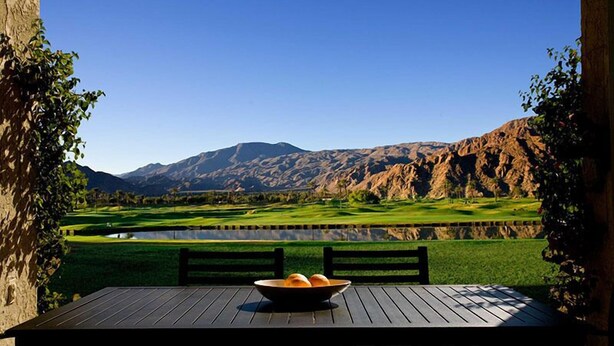 A table with a bowl of bread and a view of a golf course and mountains. - Santa Rosa Cove #50, 3 Bedrooms   3.5 Baths  La Quinta City Permit 063498 (La Quinta)