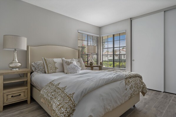 A bedroom with a bed, bedside tables, a lamp, and a window with blinds. - Santa Rosa Cove #57, 3 bedroom/2bath, Permit 063491 (La Quinta)