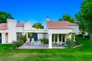 A modern house with a patio, outdoor seating, and a view of the ocean. - Beautiful Home on Golf Course with Amazing Mtn Views! Permit 063495 (La Quinta)