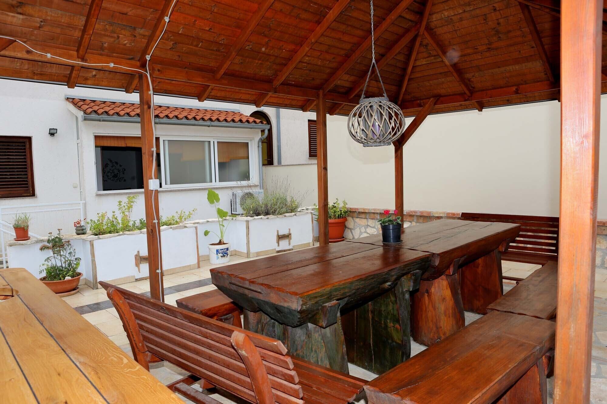 An outdoor wooden pergola with a dining table and benches.