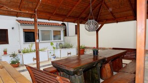 Una pérgola de fusta a l'aire lliure amb taula i bancs.