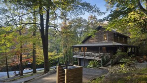 A rustic cabin with a porch and a stone fireplace. - Callie's Cabin on the Creek: 3BR w/ Firepit, Dock & Canoe | Pet Friendly (Highlands)