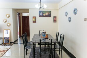 Enjoy meals with friends and family at this dining area, featuring a beautifully set table and elegant artwork.