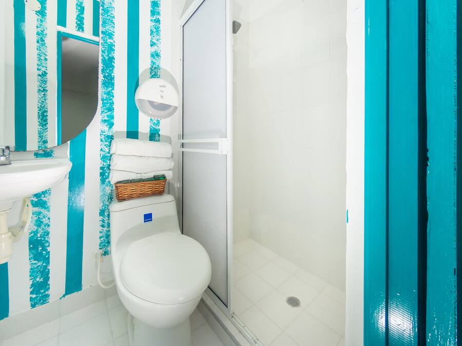 Un baño con lavamanos blanco, inodoro y zona de ducha.