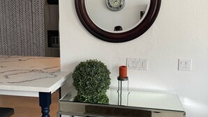 Une salle de bain moderne avec un miroir rond, une petite plante en pot et un meuble vitré.