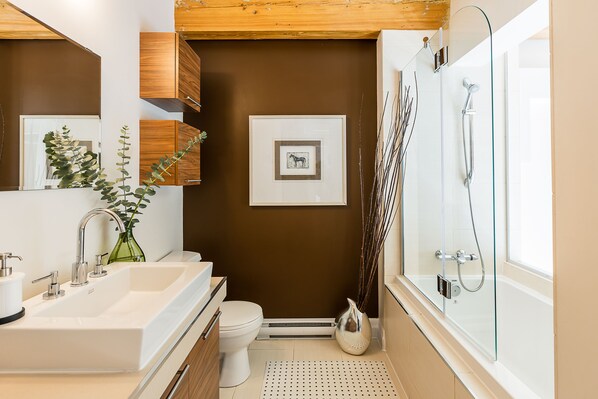A modern bathroom with a large sink, toilet, and shower.